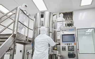 Scientists in white lab suits conducting experiments in a laboratory